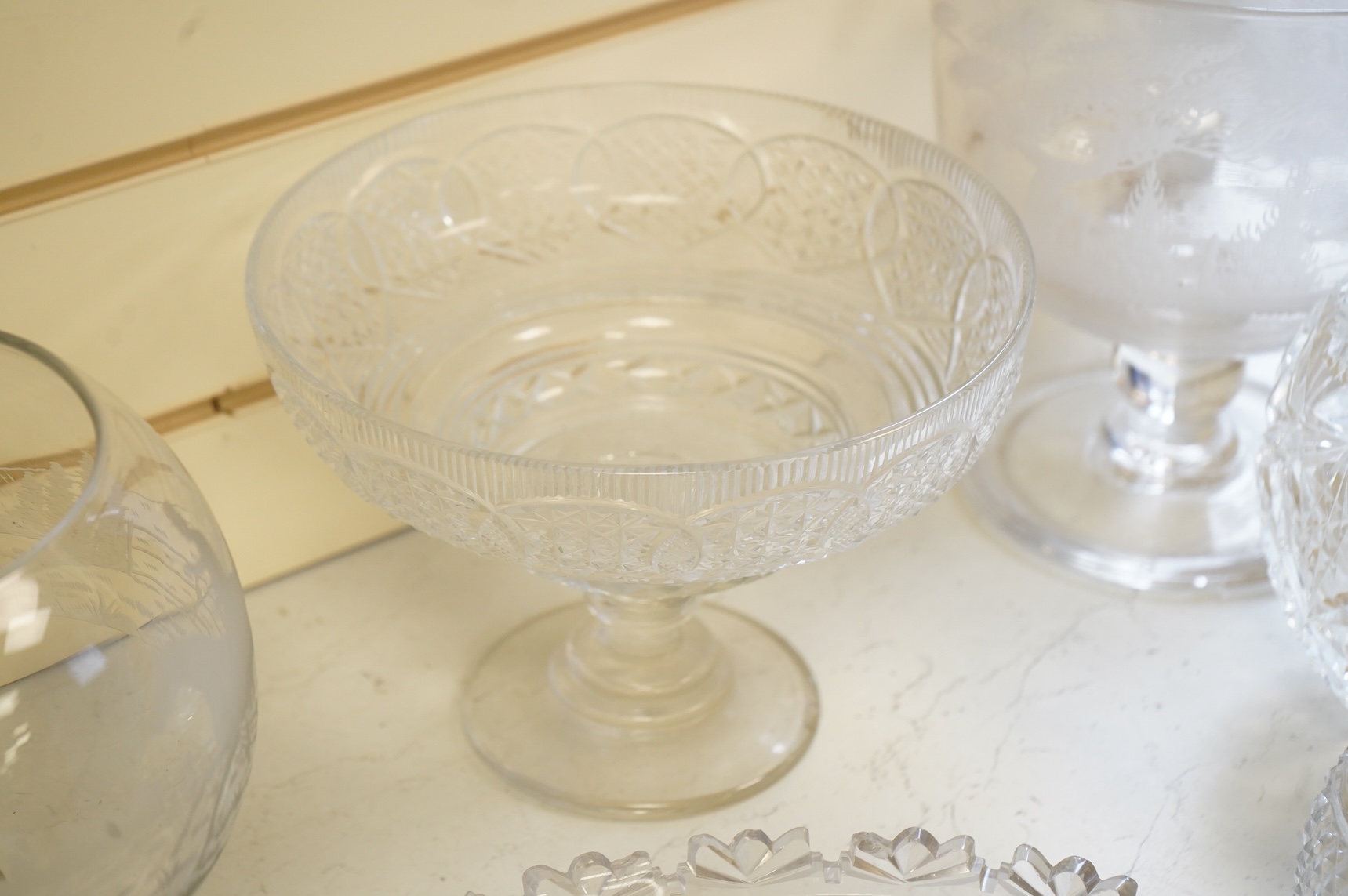 Two footed glass bowls engraved with racing and hunting scenes, an early 19th century oval cut glass fruit bowl, another, modern, together with a small Regency mallet shaped decanter, with an enamel label ‘’Whisky’’, (6)